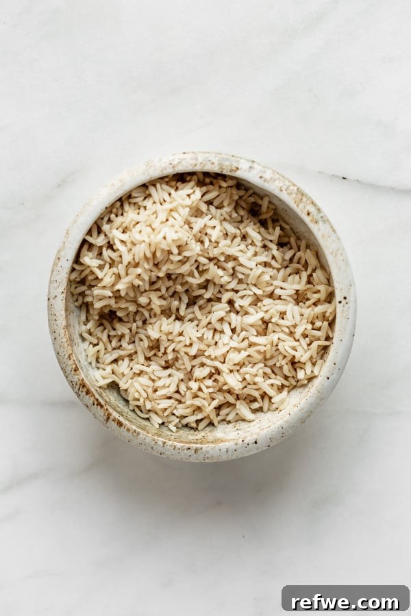 Legendary Dragon Bowls 3 A simple ceramic bowl holding perfectly cooked, fluffy brown rice, ready to be topped with fresh ingredients.