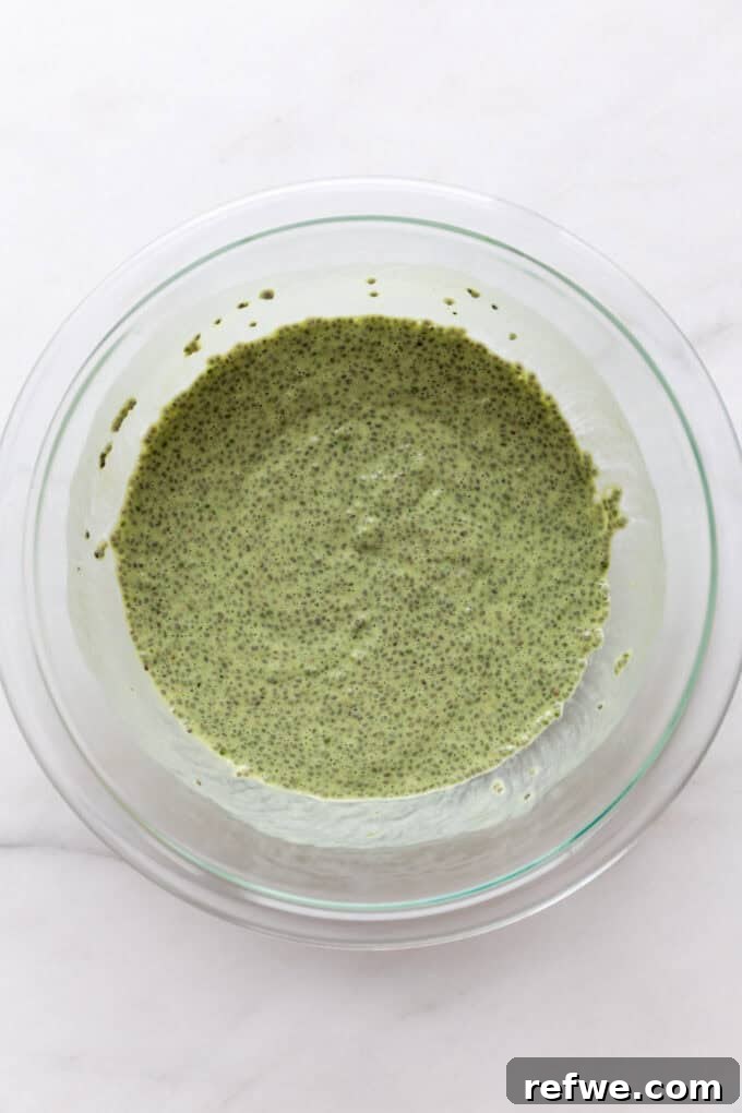 Vibrant Matcha Chia Pudding 6 A bowl of vibrant green matcha chia pudding, covered with plastic wrap, placed in a refrigerator to chill and set.