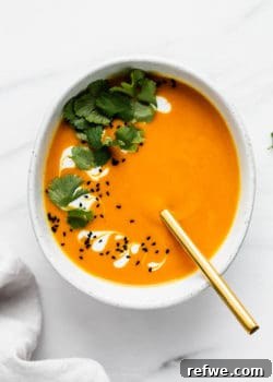 Thai carrot ginger soup in a bowl with spoon