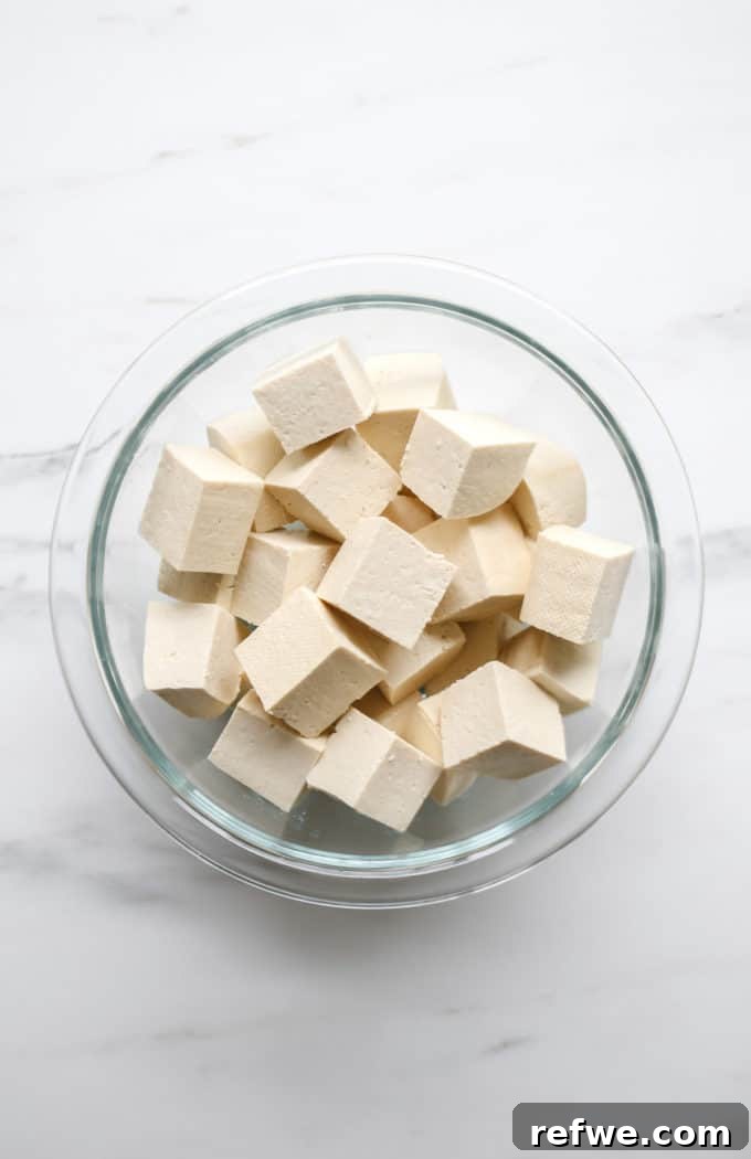 Creamy Thai Coconut Tofu Curry 4 Neatly cubed extra-firm tofu resting in a clear bowl, ready for cooking.
