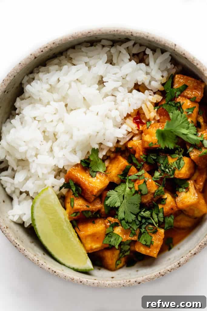 Creamy Thai Coconut Tofu Curry 8 A beautifully plated bowl of coconut curry tofu topped with fresh cilantro, accompanied by a side of rice, ready to be enjoyed.