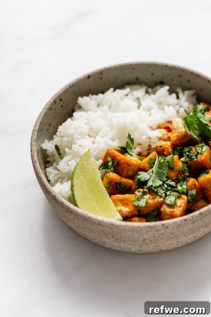 Creamy Thai Coconut Tofu Curry 9 A beautifully composed image of Thai Coconut Curry Tofu served with jasmine rice and a fresh lime wedge, inviting a flavorful meal.