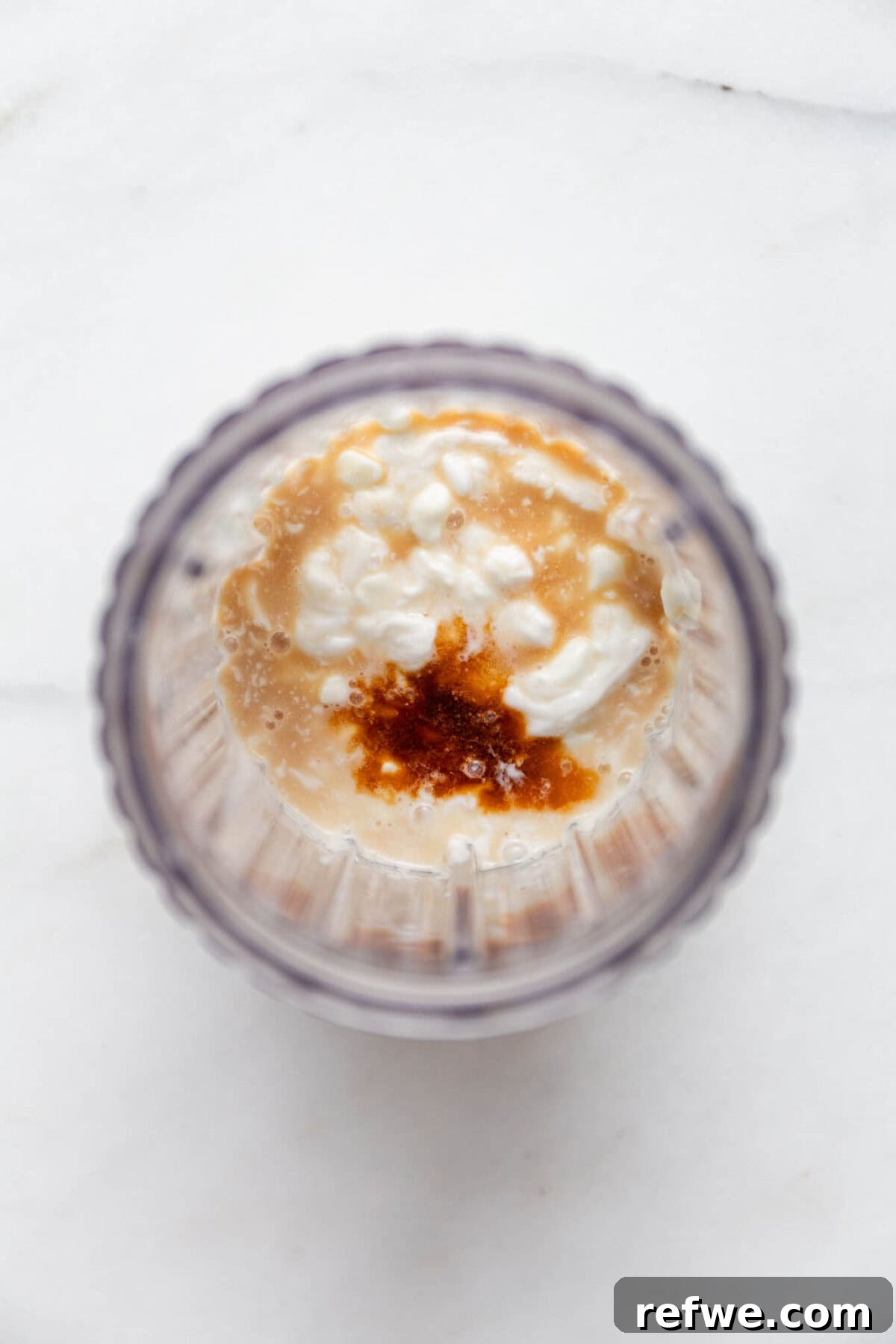 Silky Chocolate Chia Pudding 4 Cottage cheese, full-fat coconut milk, maple syrup, and vanilla extract are measured into a blender container, ready for blending.