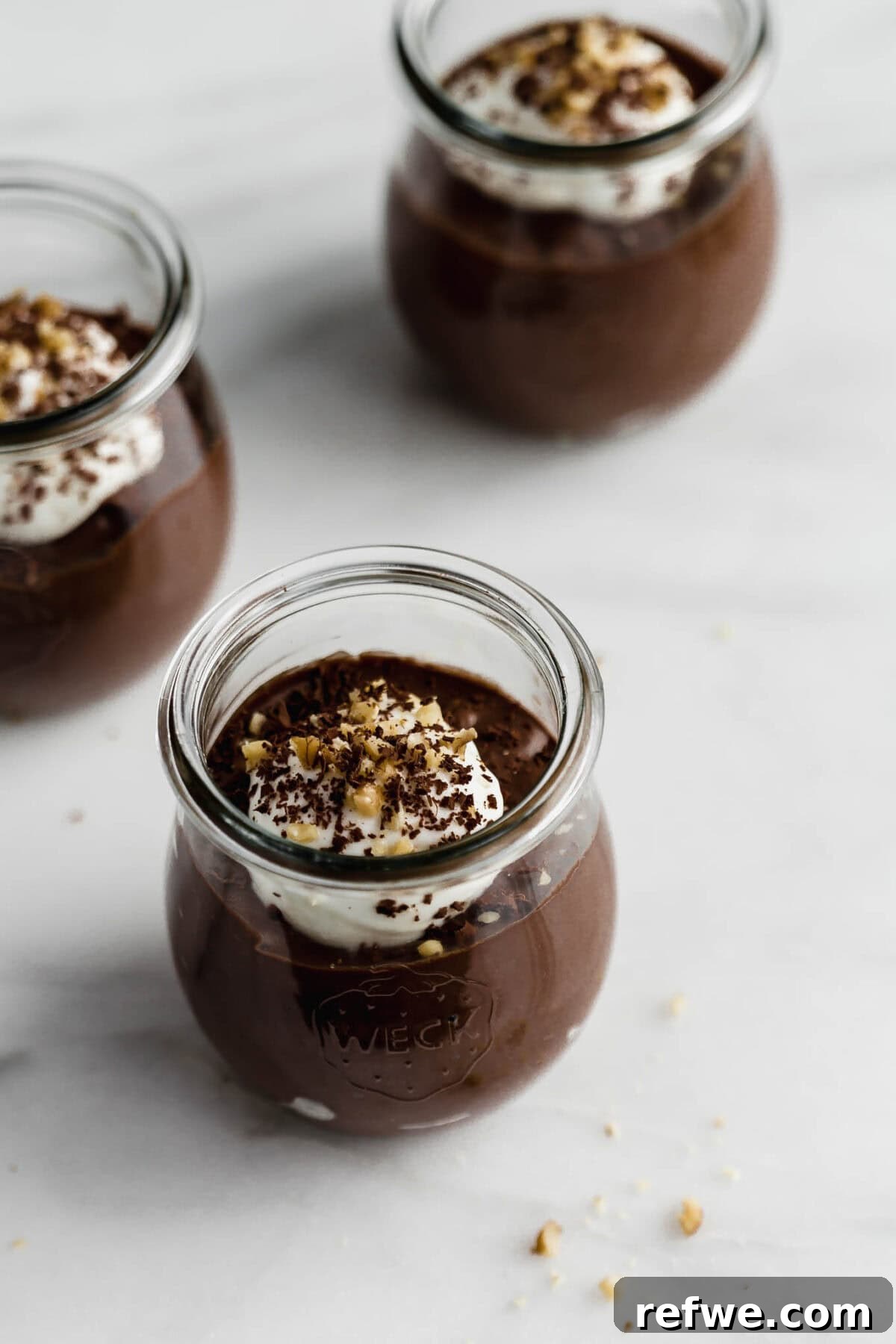 Silky Chocolate Chia Pudding 9 Three elegant cups of perfectly set chocolate chia mousse, each topped with a dollop of yogurt, ready to be garnished and served.