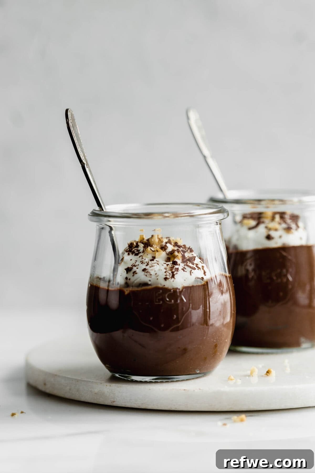 Silky Chocolate Chia Pudding 10 Two elegant jars of chocolate chia mousse, each with a spoon, inviting indulgence and showcasing the rich, creamy texture.