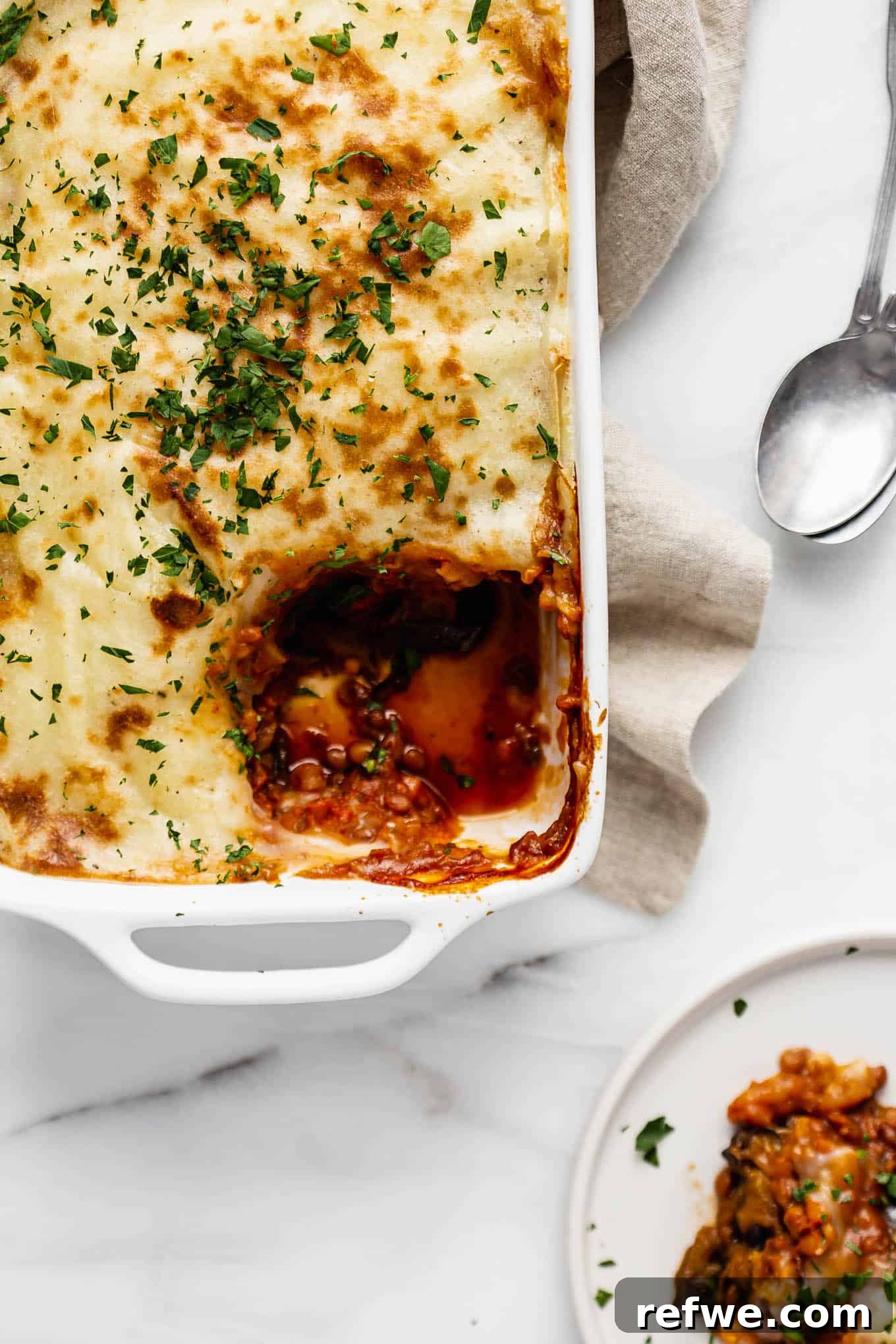 Vegan moussaka with a scoop taken out of it on a plate