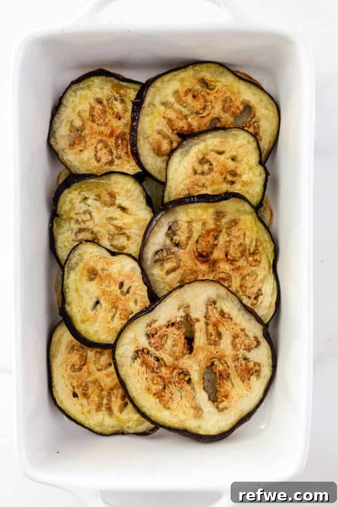 sliced roasted eggplant layered on a baking dish