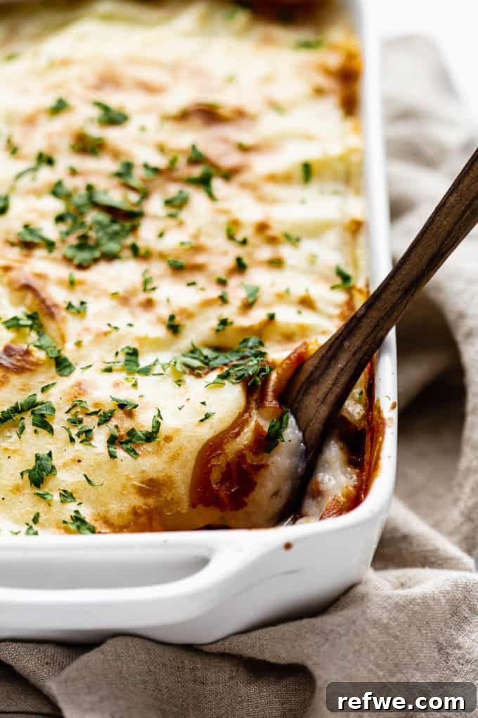 A slice of vegan moussaka on a plate with a fork