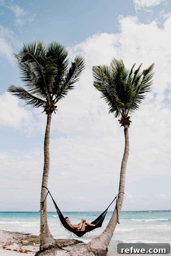 Tulum's Gastronomic Gems: A Foodie's Journey 2 Person lounging in a hammock on a pristine beach in Tulum, Mexico, with turquoise waters in the background