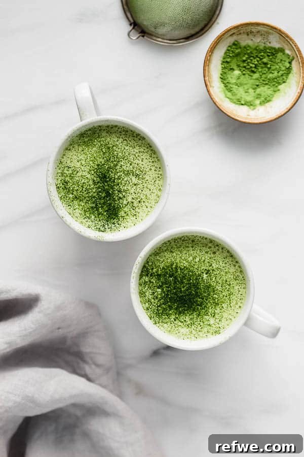 Close-up of a mug filled with a vibrant green matcha tea latte, showcasing its creamy texture.
