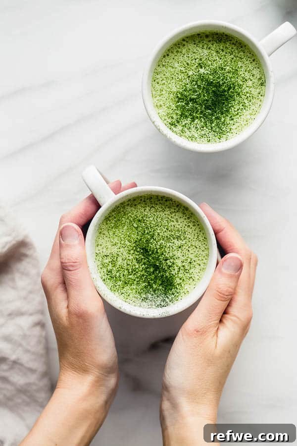 Another perspective of a mug of matcha latte, highlighting the frothy top.