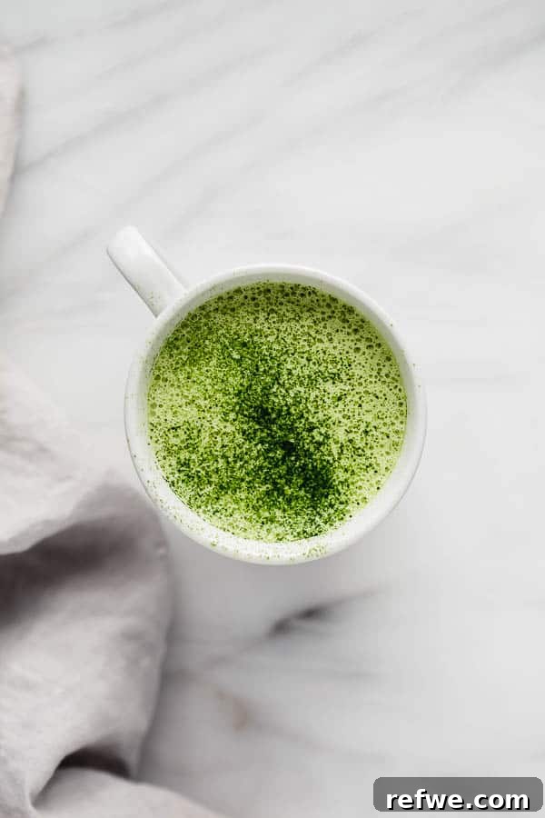 A close-up shot of a single mug of matcha tea latte, showcasing the steam and inviting warmth.