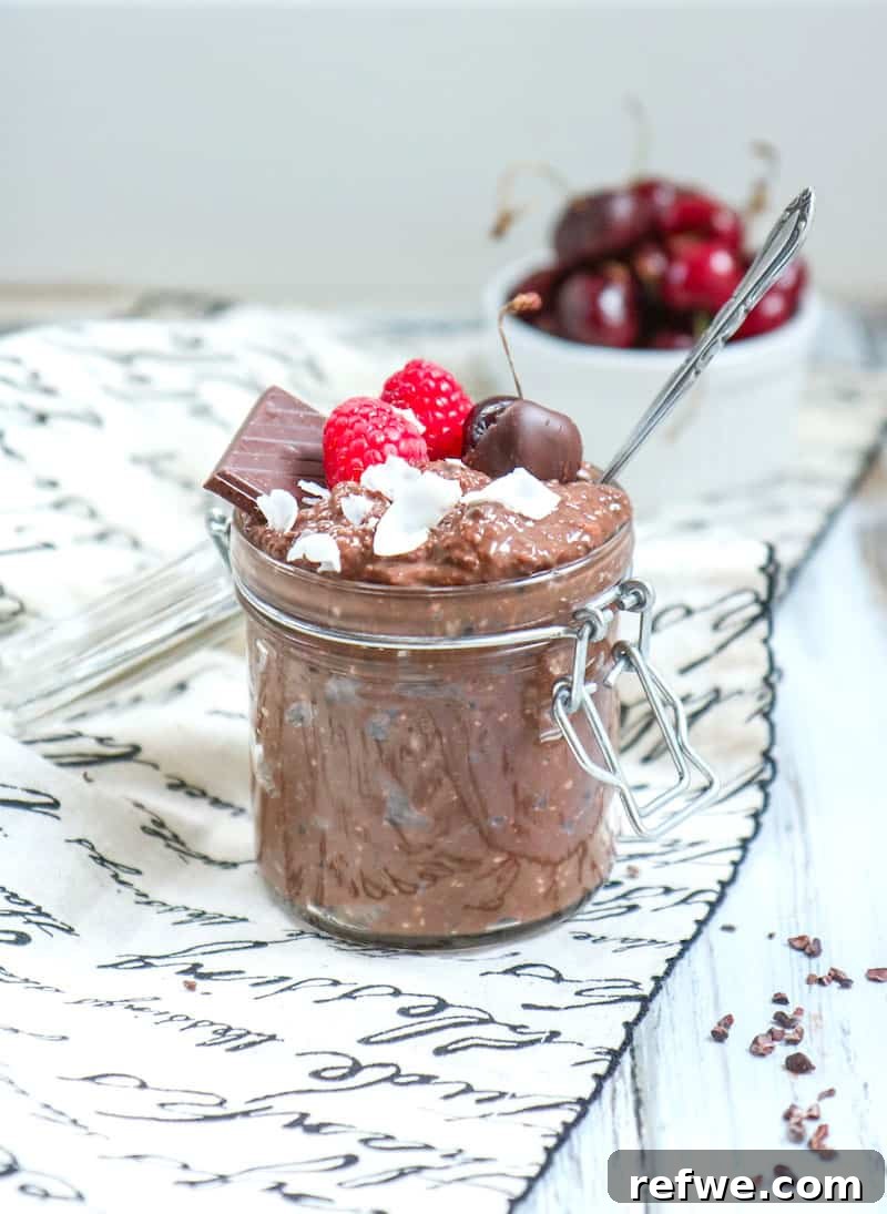 Decadent Brownie Batter Overnight Oats 2 Rich, creamy brownie batter overnight oats in a glass jar, garnished with fresh berries.