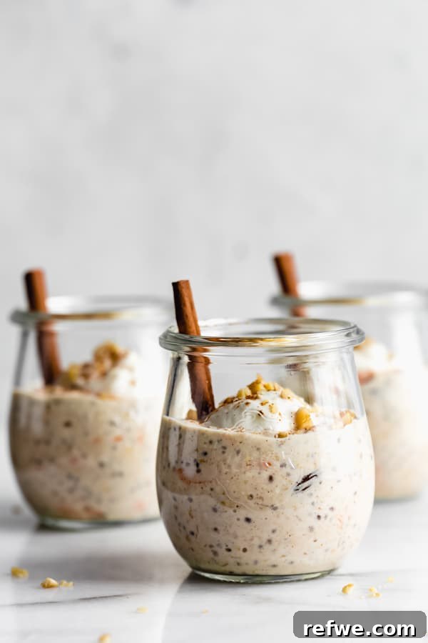 Three small cups of carrot cake overnight oatmeal, each garnished with yogurt and walnuts, ready to be enjoyed.