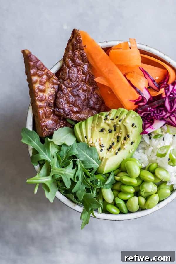 Vibrant Ginger Tempeh Poke 4 A close-up of the finished Ginger Tempeh Poke Bowl, highlighting the texture of the marinated tempeh cubes, glistening with sauce, surrounded by fresh, colorful vegetables.