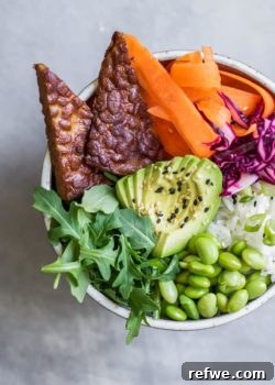 Ginger Tempeh Poke Bowls, featuring cubed tempeh, fresh vegetables, and rice in a colorful arrangement.