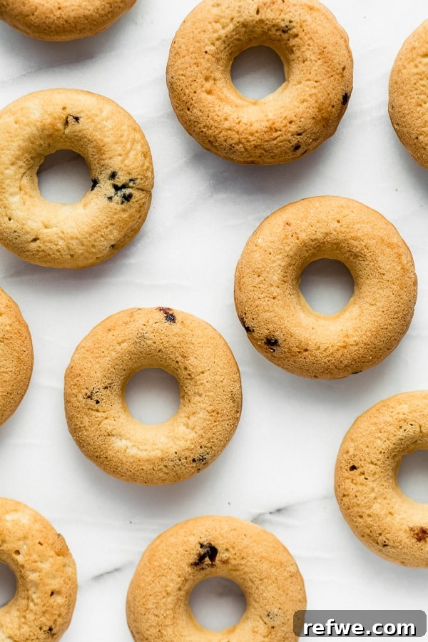 Blueberry Bliss Vegan Donuts 3 A close-up of a stack of fluffy, glazed vegan blueberry donuts, showcasing their inviting texture and rich color.