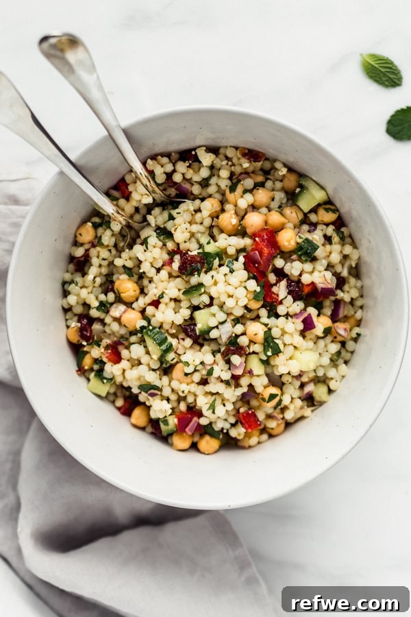 A large bowl of Israeli couscous salad, showcasing the variety of ingredients and vibrant colors