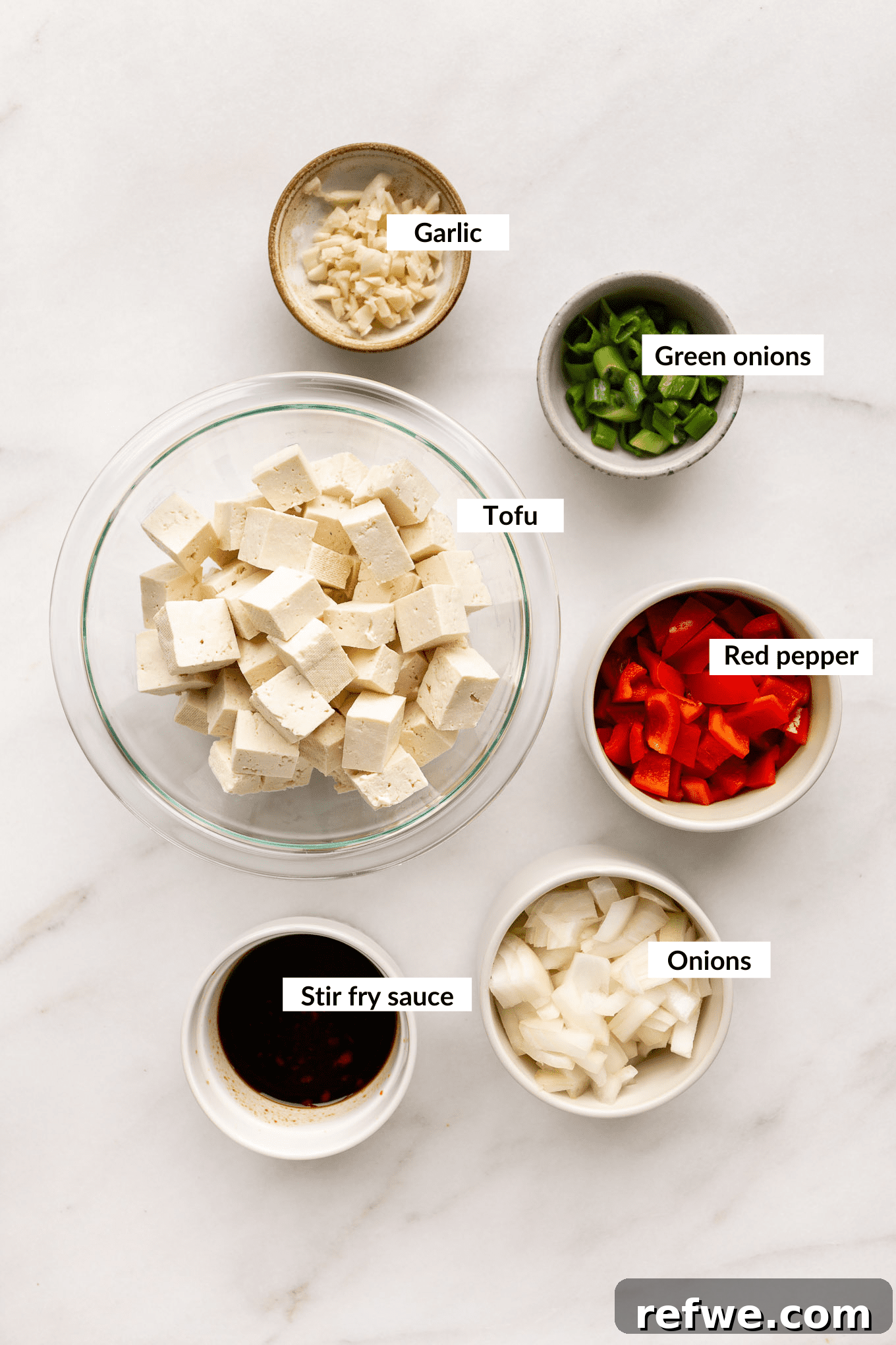 Effortless Kung Pao Tofu 3 A spread of fresh ingredients including tofu, bell peppers, onions, and various sauces, prepped for Kung Pao Tofu.