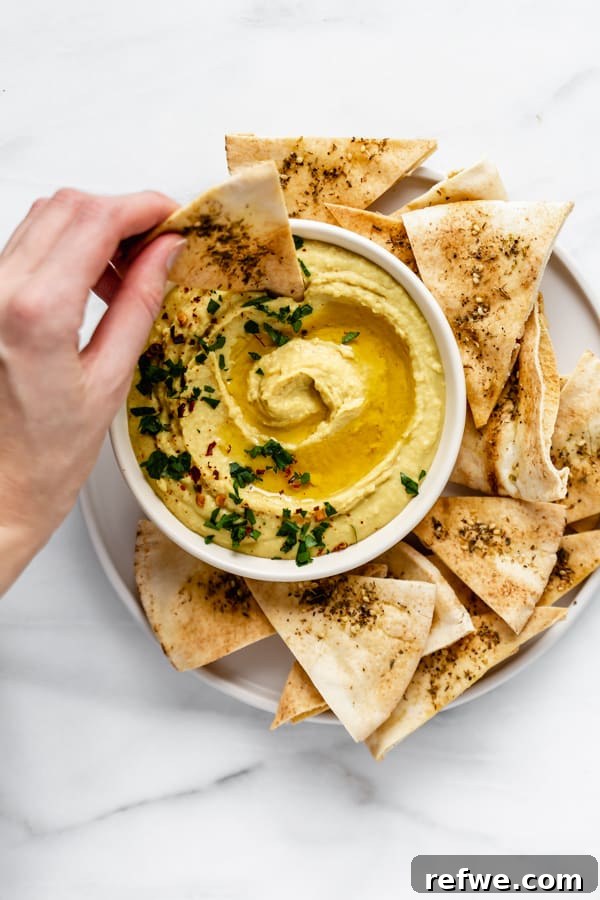 Freshly baked homemade pita chips, golden and crispy, seasoned with za'atar, perfect for dipping.