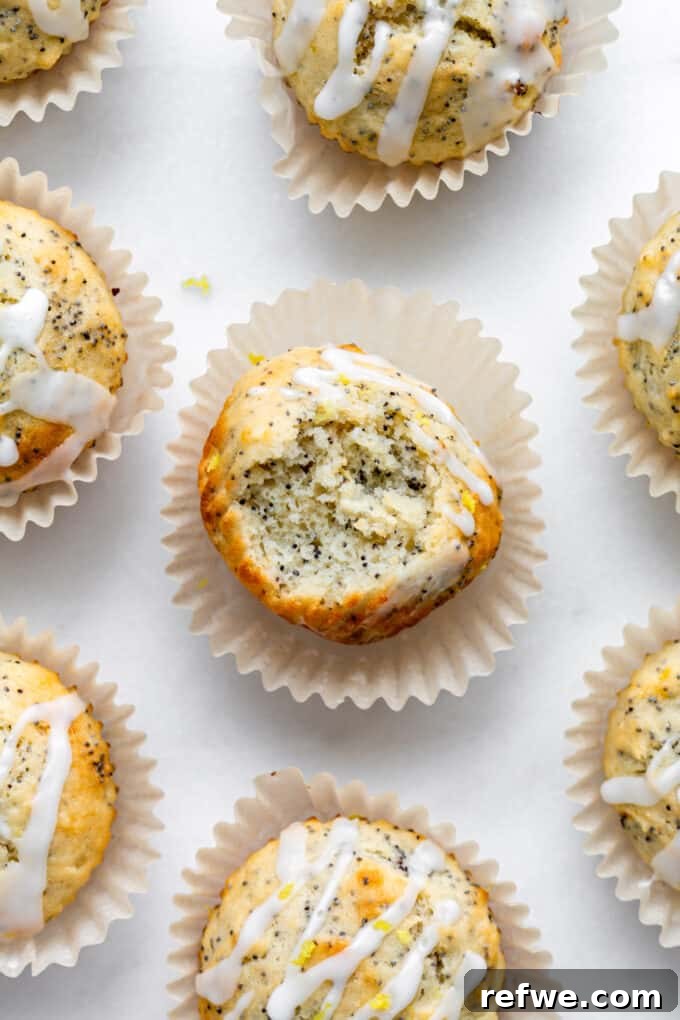 Wholesome Lemon Poppy Seed Delights 11 A cluster of freshly baked lemon poppy seed muffins, some drizzled with a light lemon glaze, arranged on a cooling rack.