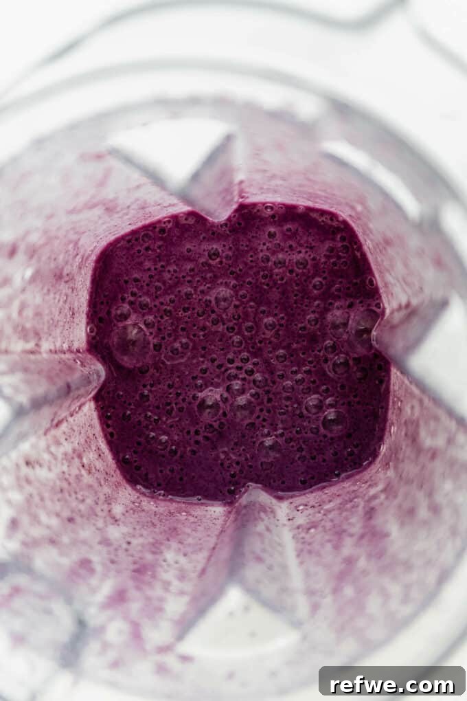 Velvety Blueberry Avocado Blend 5 A perfectly blended blueberry avocado smoothie swirling in a high-speed blender, showcasing its rich, creamy texture.