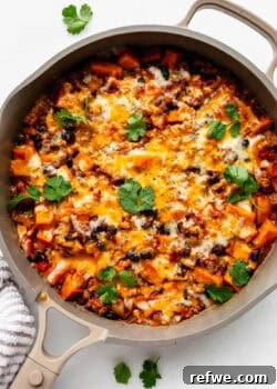 ground turkey sweet potato skillet topped with melted cheese and cilantro.