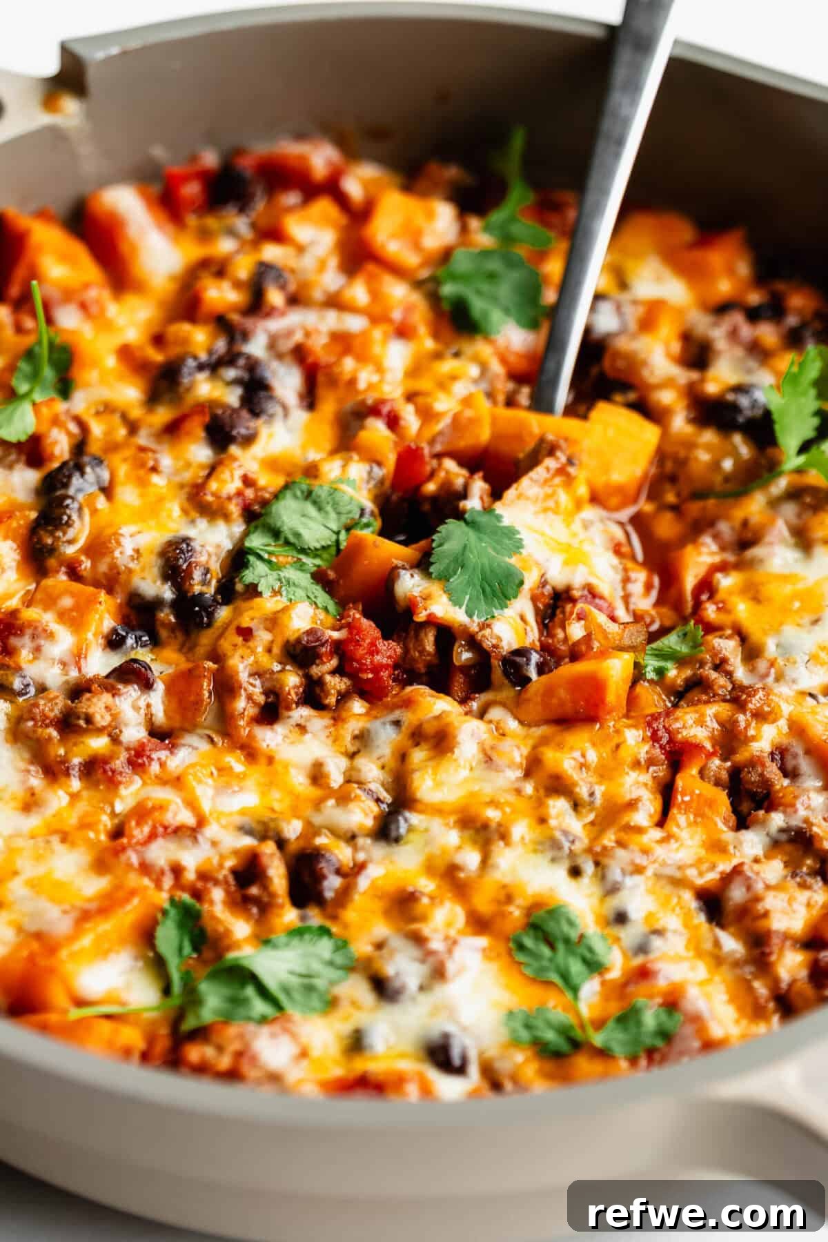Ground Turkey and Sweet Potato Taco Skillet Recipe 9 A sweet potato taco skillet with melted cheese topped with cilantro.