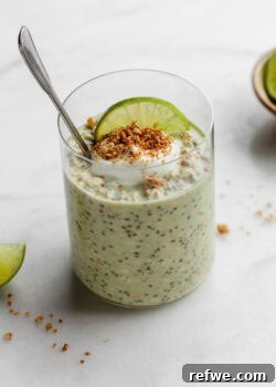 Key lime pie overnight oats topped with yogurt and graham cracker crumbs with a spoon in it.