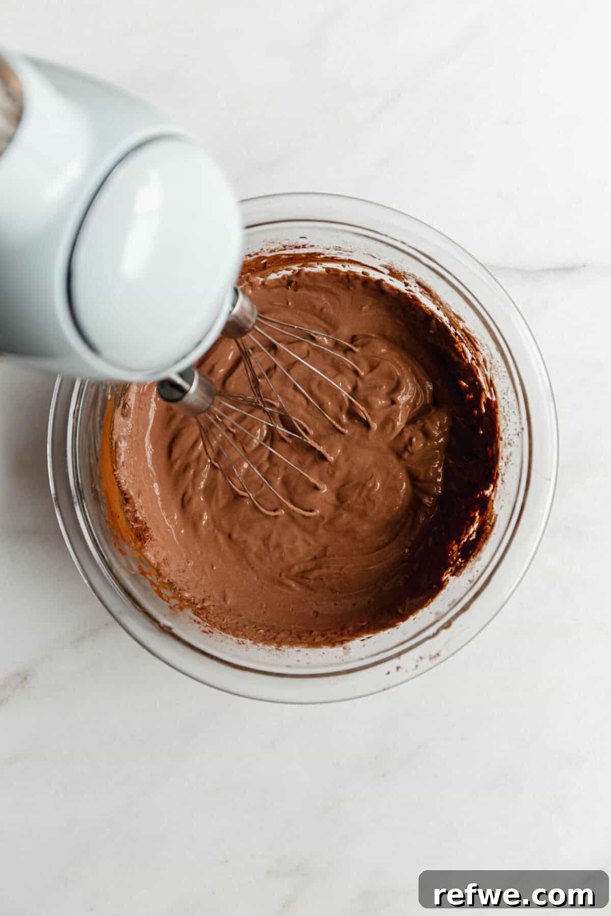 Creamy Greek Yogurt Chocolate Mousse Recipe for Decadent Dessert 5 Using a hand mixer to blend Greek yogurt chocolate mousse ingredients in a glass bowl.