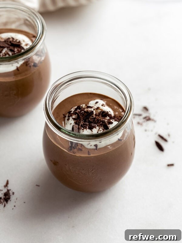 Creamy Greek Yogurt Chocolate Mousse Recipe for Decadent Dessert 9 cottage cheese chocolate mousse in a small jar with yogurt and chocolate on top.