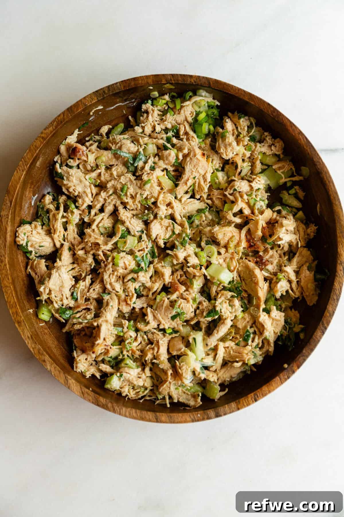 Jalapeño Popper Chicken Salad Recipe — Creamy, Spicy Lunch Idea 8 Overhead close-up of jalapeno popper chicken salad mixed together in a wooden bowl.