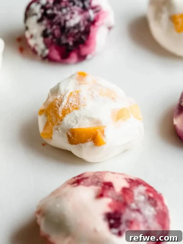 Chewy Rice Paper Mochi Recipe: Step-by-Step Homemade Treat 11 Mango, strawberry and blueberry rice paper mochi on a marble surface.