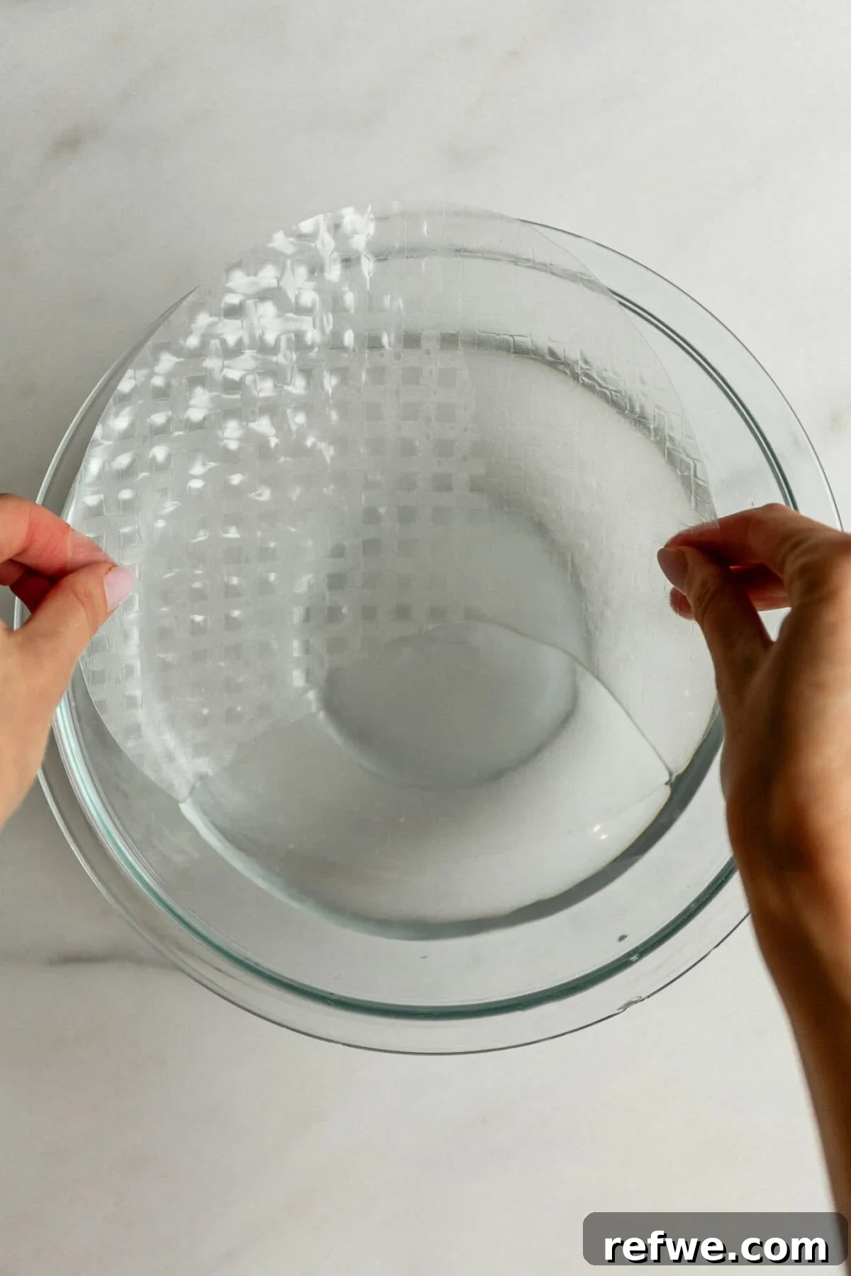 Chewy Rice Paper Mochi Recipe: Step-by-Step Homemade Treat 4 Hands soaking a rice paper sheet in a bowl of water to make rice paper mochi