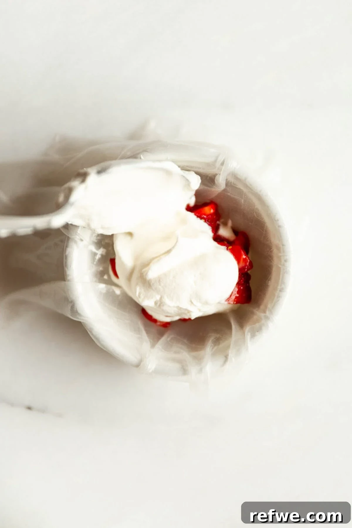 Chewy Rice Paper Mochi Recipe: Step-by-Step Homemade Treat 7 Rice paper dough being wrapped around strawberry filling to make mochi
