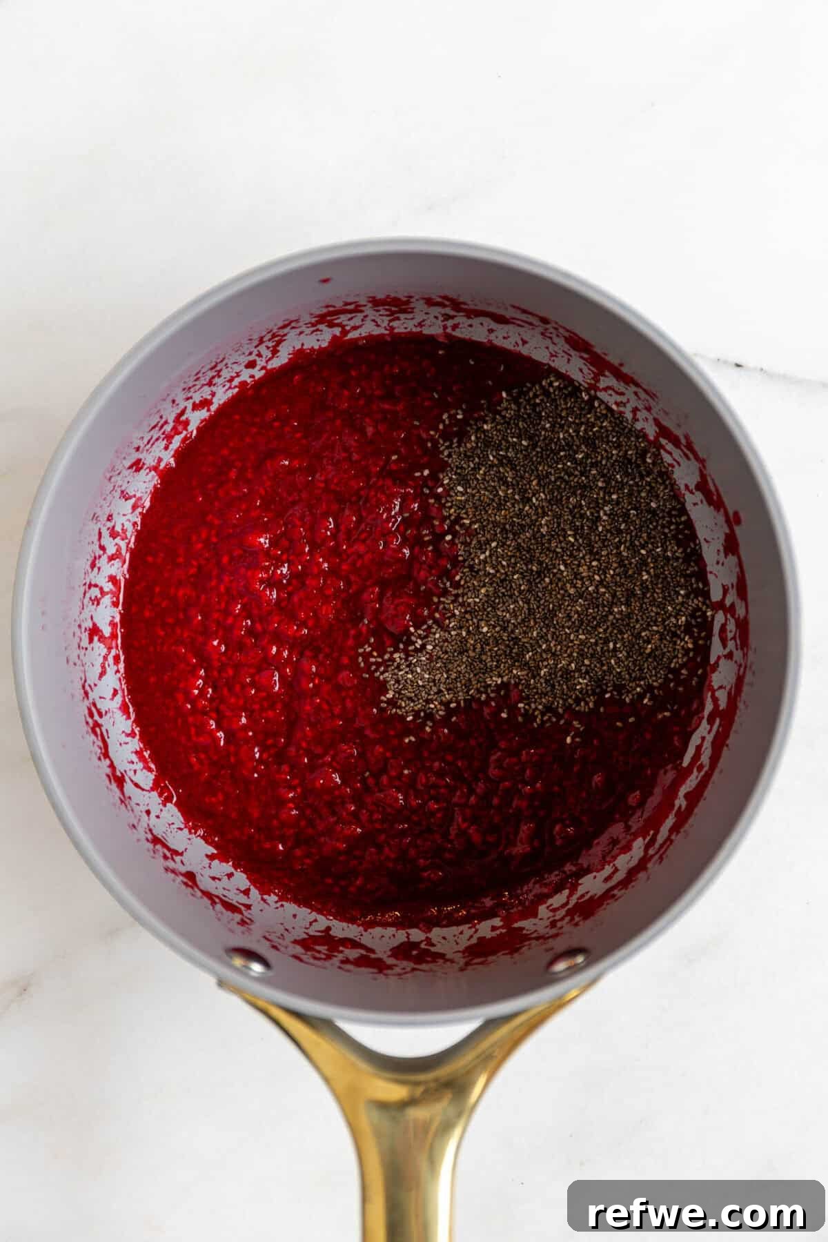Chocolate Chia Jam Energy Bites: No-Bake Snack Recipe 4 Raspberry chia seed jam cooking in a saucepan with chia seeds added.
