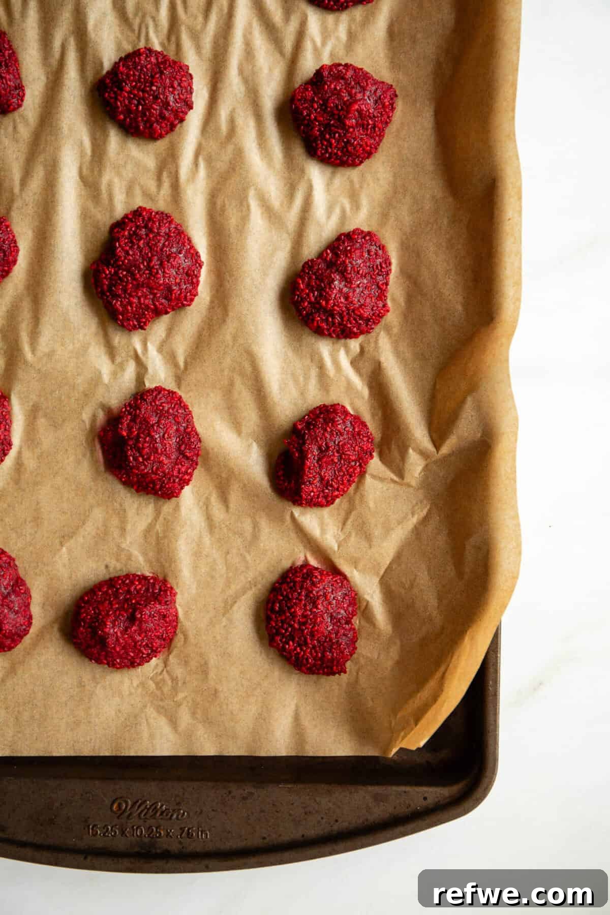 Chocolate Chia Jam Energy Bites: No-Bake Snack Recipe 7 frozen raspberry chia jam clusters on a baking sheet.
