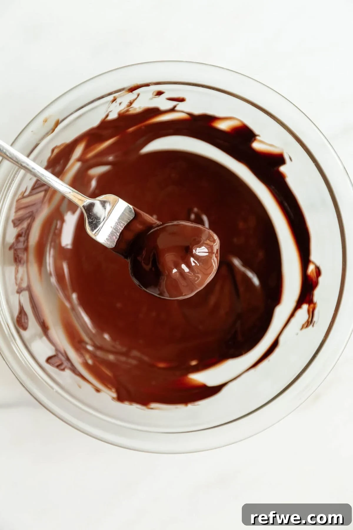 Chocolate Chia Jam Energy Bites: No-Bake Snack Recipe 9 a chia jam bite dipped into a bowl of dark chocolate.