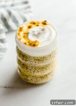 Glass jar of passionfruit chia pudding with layers of chia pudding topped with creamy yogurt and passionfruit pulp.