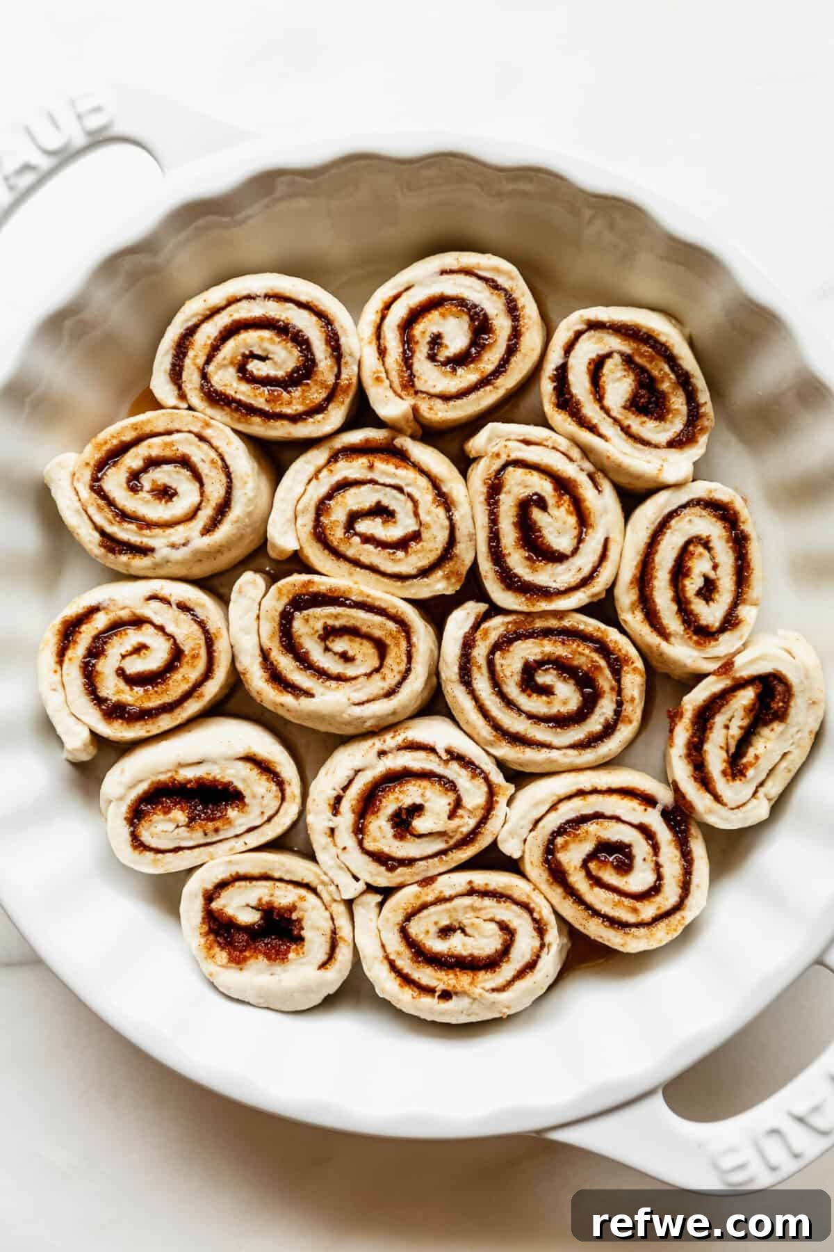 Cottage Cheese Cinnamon Rolls Recipe: Soft and Fluffy 11 Unbaked cottage cheese cinnamon rolls in a round baking pan.
