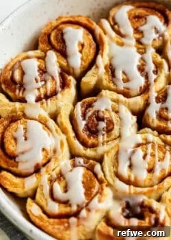 Close-up of glazed cottage cheese cinnamon rolls with icing drizzle.