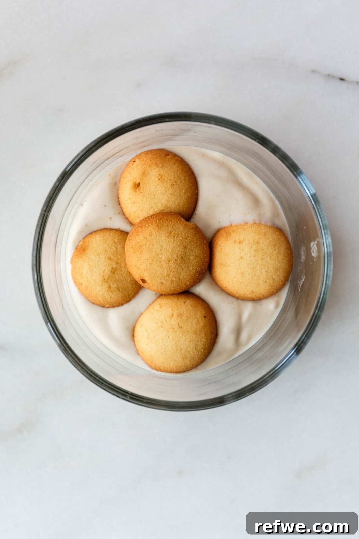 High-Protein Banana Yogurt Pudding Recipe with Greek Yogurt 6 High protein banana pudding topped with vanilla wafer cookies in a glass bowl.