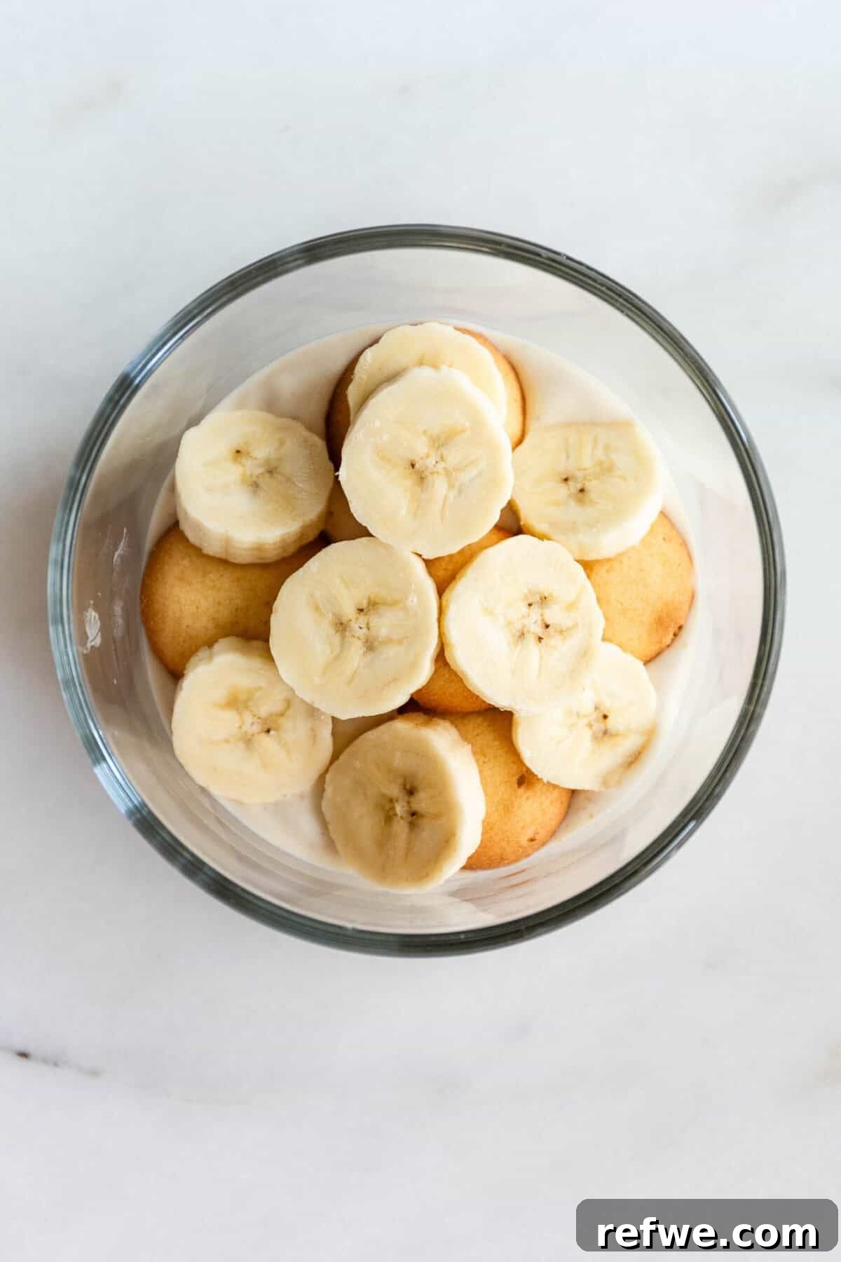 High-Protein Banana Yogurt Pudding Recipe with Greek Yogurt 7 High protein banana pudding topped with fresh banana slices in a glass bowl.