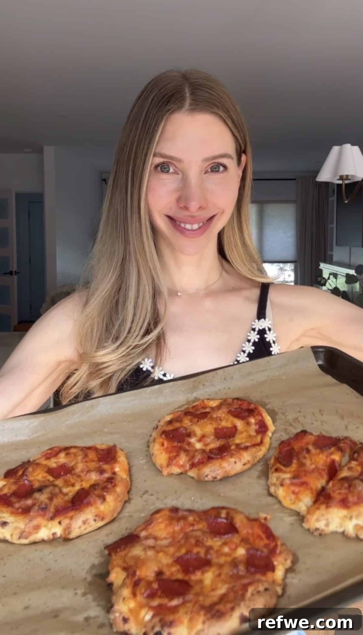 A girl holding a tray of cottage cheese pizza buns.