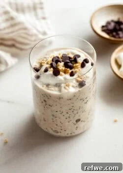 A jar of smores overnight oats topped with graham cracker crumbs and chocolate chips.