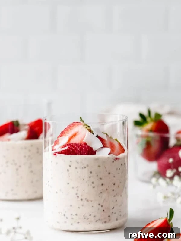 two cups of protein overnight oats with strawberries and coconut flakes