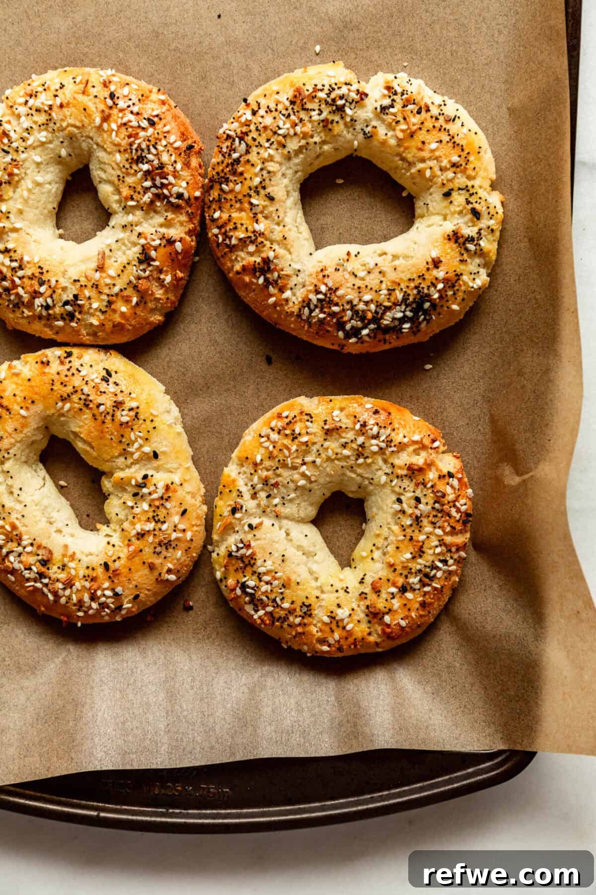 Cottage Cheese and Almond Flour Bagel Recipe 12 four Cottage Cheese Almond Flour Bagels on a baking sheet with parchment paper.