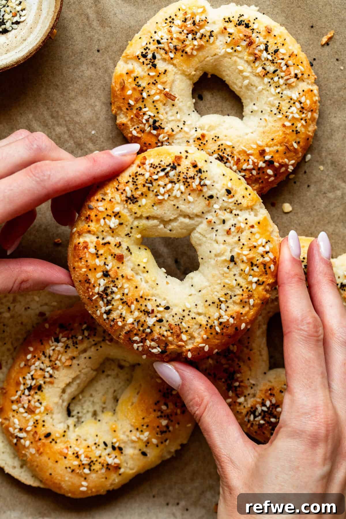 Cottage Cheese and Almond Flour Bagel Recipe 13 Two hands holding a Cottage Cheese Almond Flour Bagel.