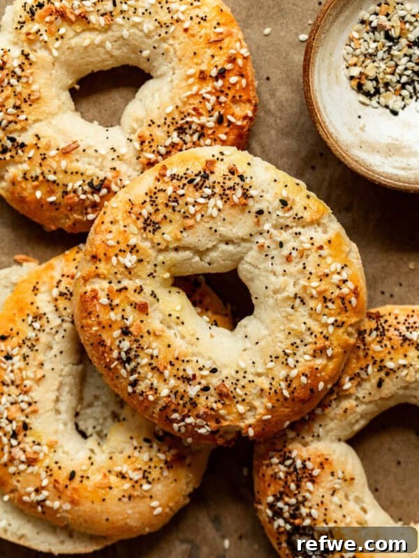 Cottage Cheese Almond Flour Bagels on parchment paper with a small bowl of everything bagel spice on the side.