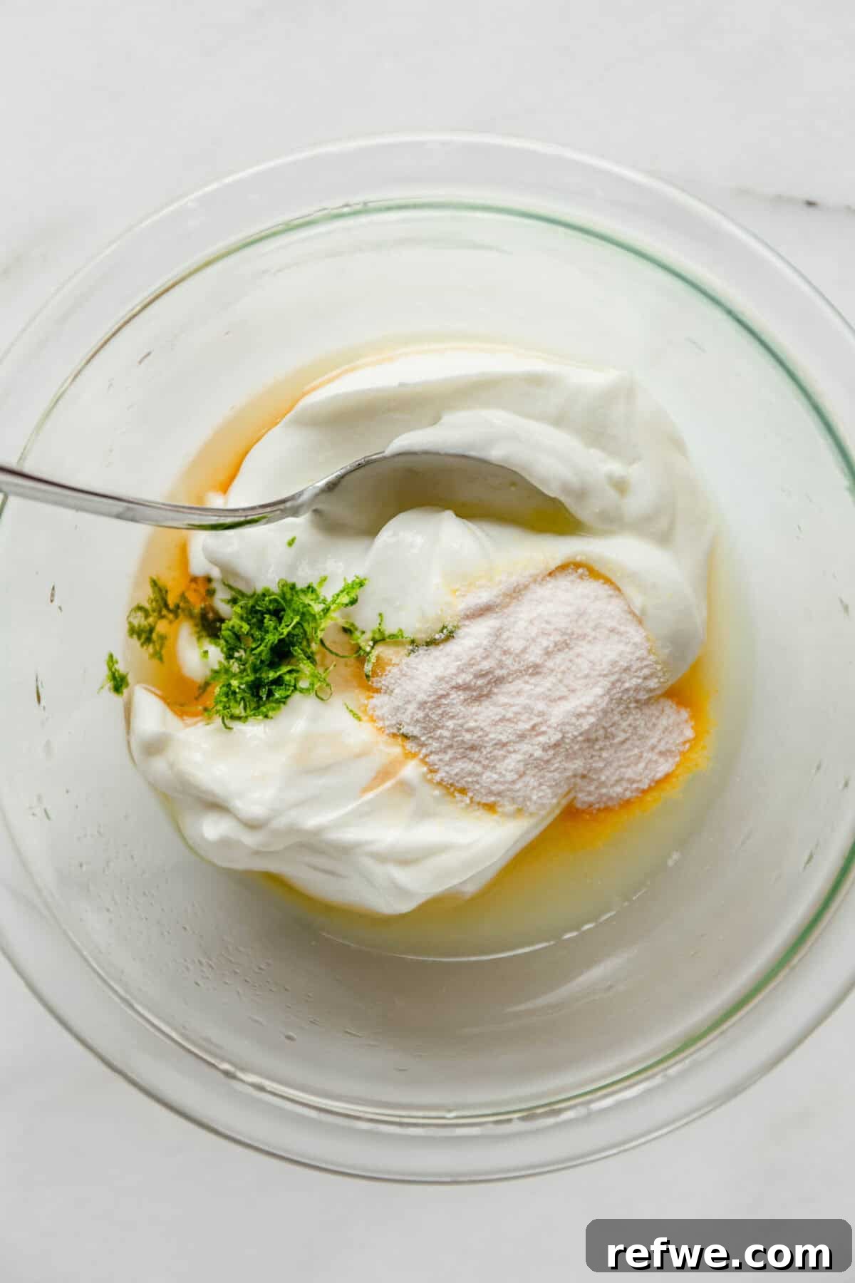 Mini Key Lime Pie Pudding Jars with Greek Yogurt 4 Bowl of Greek yogurt, lime zest, and sweetener being mixed together for key lime pie filling.